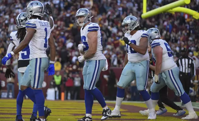 Dallas Cowboys tight end Luke Schoonmaker (86), center, celebrates after scoring a 22-yard touchdown during the second half of an NFL football game against the Washington Commanders, Sunday, Nov. 24, 2024, in Landover, Md. (AP Photo/Stephanie Scarbrough)