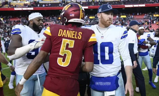 Washington Commanders quarterback Jayden Daniels (5) Dallas Cowboys quarterback Cooper Rush (10) shake hands after an NFL football game, Sunday, Nov. 24, 2024, in Landover, Md. The Cowboys on 34-26. (AP Photo/Nick Wass)