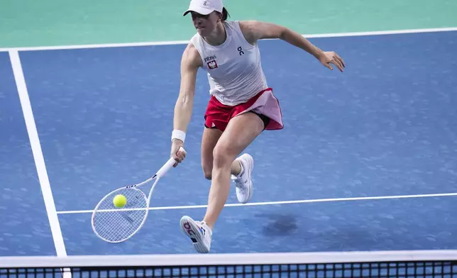 Poland's Iga Swiatek returns the ball against Italy's Jasmine Paolini during the Billie Jean King Cup semi-final tennis match at Martin Carpena Sports Hall in Malaga, southern Spain, on Monday, Nov. 18, 2024. (AP Photo/Manu Fernandez)