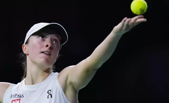 FILE - Poland's Iga Swiatek serves against Italy's Jasmine Paolini during the Billie Jean King Cup semi-final tennis match at Martin Carpena Sports Hall in Malaga, southern Spain, on Monday, Nov. 18, 2024. (AP Photo/Manu Fernandez, File)