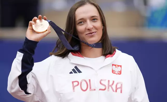 FILE - Poland's Iga Swiatek shows her bronze medal after the Women's Singles tennis final at the Roland Garros stadium at the 2024 Summer Olympics, Saturday, Aug. 3, 2024, in Paris, France. (AP Photo/Manu Fernandez, File)