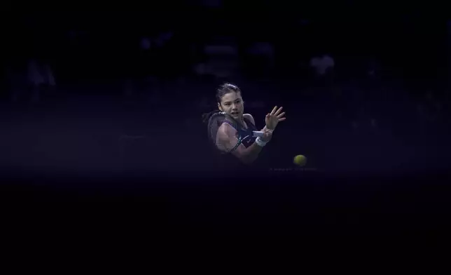 Emma Raducanu of Britain returns a the ball to Canada's Rebecca Marino during the Billie Jean King Cup Finals, at the Martin Carpena Sports Hall, in Malaga, southern Spain, on Sunday, Nov. 17, 2024. (AP Photo/Manu Fernandez)