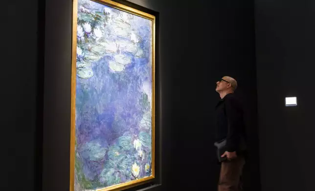 FILE - A man looks at "Nympheas," by Claude Monet, during an auction preview at Sotheby's in New York, Monday, Nov. 11, 2024. (AP Photo/Eduardo Munoz Alvarez)