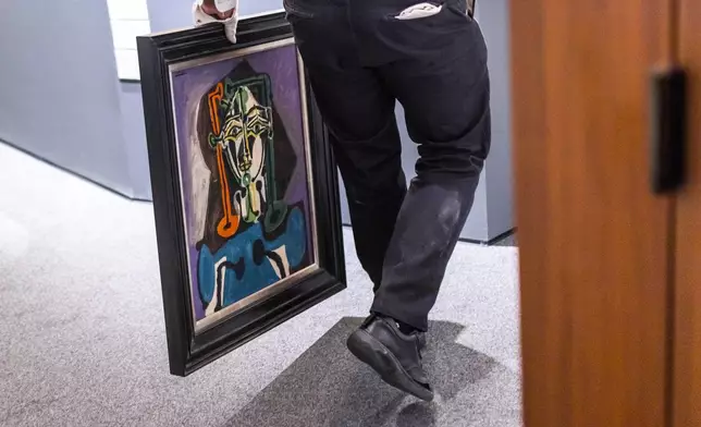 A Sotheby's staff carries "Buste De Femme" by Pablo Picasso, during an auction preview at Sotheby's in New York, Monday, Nov. 11, 2024. (AP Photo/Eduardo Munoz Alvarez)