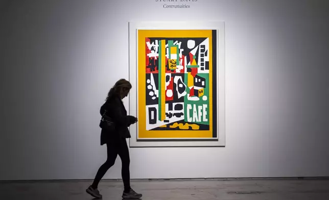 A woman walks near "Contranuities," by Stuart Davis, during an auction preview at Sotheby's in New York, Monday, Nov. 11, 2024. (AP Photo/Eduardo Munoz Alvarez)