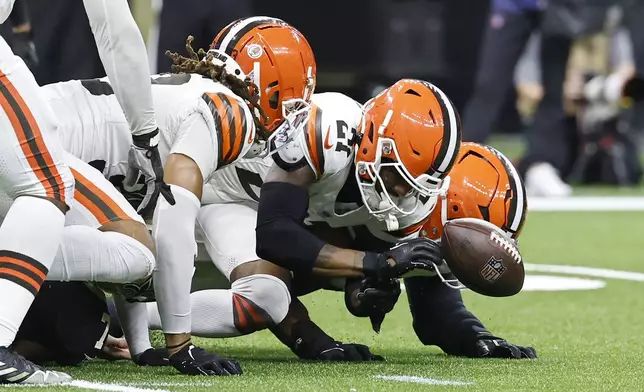 Cleveland Browns cornerback Denzel Ward, center, recovers a fumble by New Orleans Saints tight end Taysom Hill in the first half of an NFL football game in New Orleans, Sunday, Nov. 17, 2024. (AP Photo/Butch Dill)