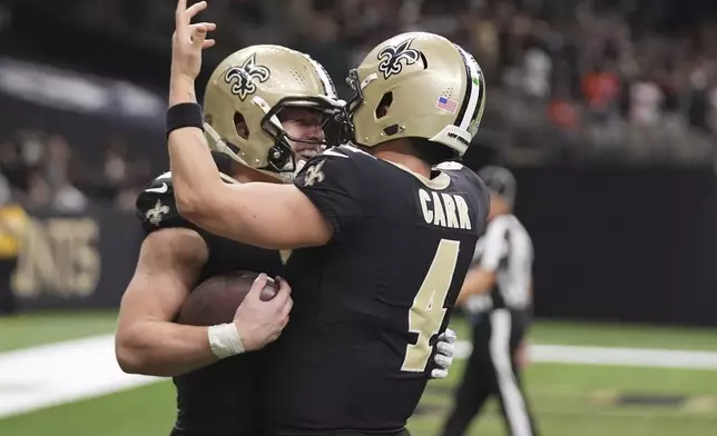 New Orleans Saints tight end Taysom Hill, left, celebrates a touchdown with quarterback Derek Carr (4) in the second half of an NFL football game in New Orleans, Sunday, Nov. 17, 2024. (AP Photo/Gerald Herbert)