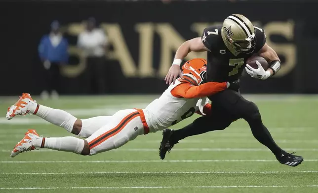 New Orleans Saints tight end Taysom Hill (7) is tackled by Cleveland Browns safety Grant Delpit, left, in the first half of an NFL football game in New Orleans, Sunday, Nov. 17, 2024. (AP Photo/Gerald Herbert)