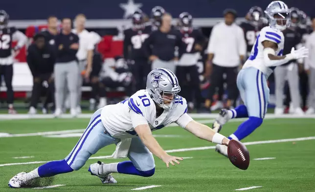 Dallas Cowboys quarterback Cooper Rush fumbles the snap against the Houston Texans during the second half of an NFL football game, Monday, Nov. 18, 2024, in Arlington, Texas. (AP Photo/Gareth Patterson)