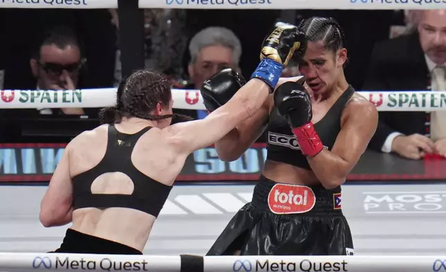 Katie Taylor, left, lands a right to Amanda Serrano during their undisputed super lightweight title bout, Friday, Nov. 15, 2024, in Arlington, Texas. (AP Photo/Julio Cortez)