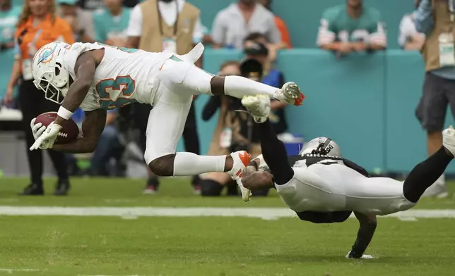 Las Vegas Raiders wide receiver DJ Turner, right, tackles Miami Dolphins wide receiver Malik Washington, left, on a punt return during the second half of an NFL football game, Sunday, Nov. 17, 2024, in Miami Gardens, Fla. (AP Photo/Lynne Sladky)