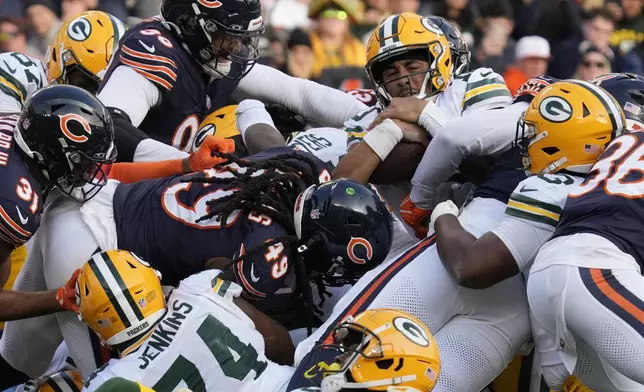 Green Bay Packers quarterback Jordan Love, top right, scores a touchdown during the second half of an NFL football game against the Chicago Bears in Chicago, Sunday, Nov. 17, 2024. (AP Photo/Nam Y. Huh)