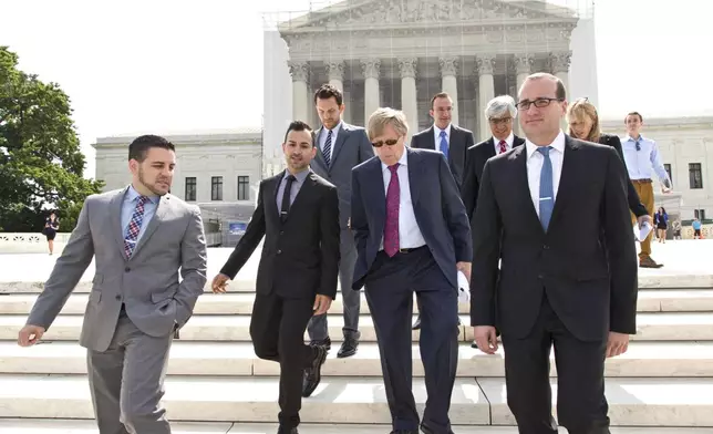 FILE - Chad Griffin, right, president of the Human Rights Campaign, leaves the Supreme Court, with Jeff Zarrillo, left, and Paul Katami, second from left, the plaintiffs in the California Proposition 8 case, and their attorney Ted Olson, center, in Washington, June 20, 2013. (AP Photo/J. Scott Applewhite, File)