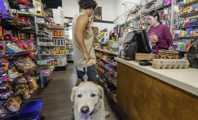 College student Jimena Sanchez, right, who studies children's development works as a part-time cashier earning minimum wage at a family store, in Los Angeles on Friday, Oct. 11, 2024. (AP Photo/Damian Dovarganes)