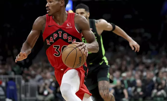 Toronto Raptors guard Ochai Agbaji (30) drives to the basket during the first half of an NBA basketball game against the Boston Celtics, Saturday, Nov. 16, 2024, in Boston. (AP Photo/Mark Stockwell)