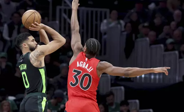 Boston Celtics forward Jayson Tatum (0) shoots over Toronto Raptors guard Ochai Agbaji (30) during the first half of an NBA basketball game, Saturday, Nov. 16, 2024, in Boston. (AP Photo/Mark Stockwell)