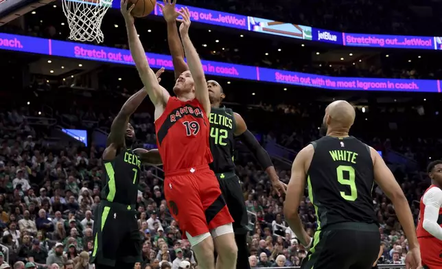 Boston Celtics guard Jaylen Brown (7) and center Al Horford (42) attempt to stop a basket by Toronto Raptors center Jakob Poeltl (19) during the first half of an NBA basketball game, Saturday, Nov. 16, 2024, in Boston. (AP Photo/Mark Stockwell)