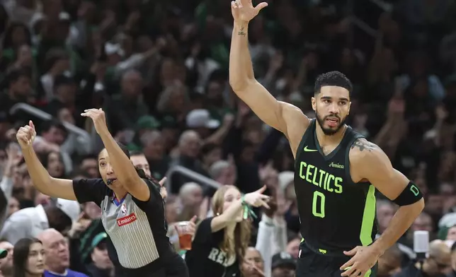 Boston Celtics forward Jayson Tatum (0) signals three after hitting an outside shot during the first half of an NBA basketball game against the Toronto Raptors, Saturday, Nov. 16, 2024, in Boston. (AP Photo/Mark Stockwell)