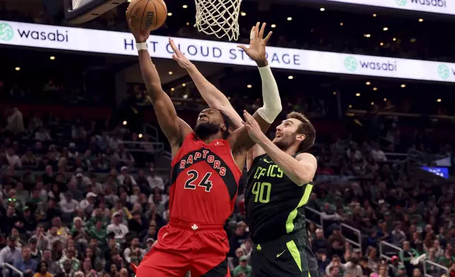 Boston Celtics center Luke Kornet (40) blocks a shot made by Toronto Raptors forward Bruno Fernando (24) during the first half of an NBA basketball game, Saturday, Nov. 16, 2024, in Boston. (AP Photo/Mark Stockwell)