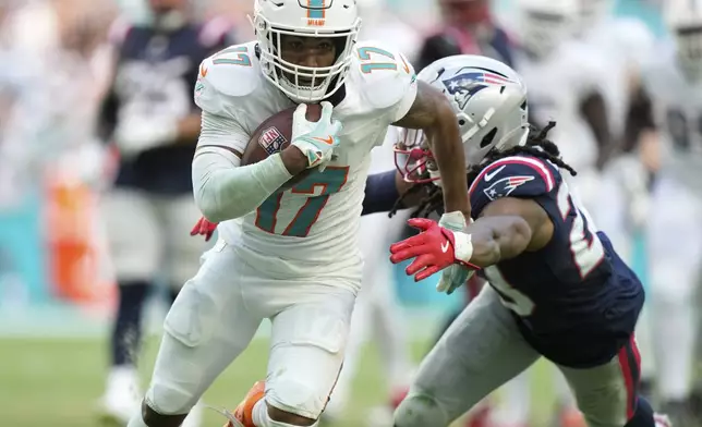 Miami Dolphins wide receiver Jaylen Waddle (17) runs for a touchdown ahead of a tackle by New England Patriots safety Kyle Dugger (23) during the second half of an NFL football game, Sunday, Nov. 24, 2024, in Miami Gardens, Fla. (AP Photo/Wilfredo Lee)