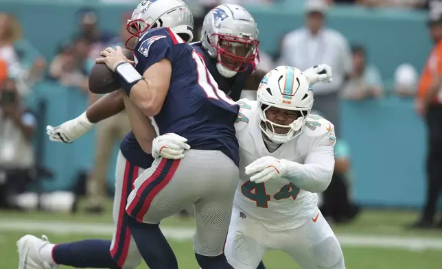 Miami Dolphins linebacker Chop Robinson (44) sacks New England Patriots quarterback Drake Maye (10) during the first half of an NFL football game, Sunday, Nov. 24, 2024, in Miami Gardens, Fla. (AP Photo/Lynne Sladky)