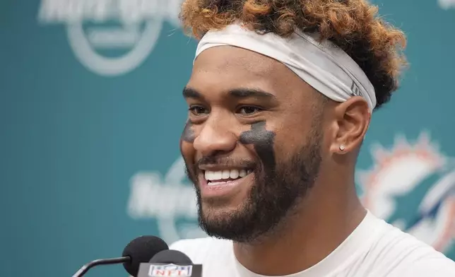 Miami Dolphins quarterback Tua Tagovailoa (1) smiles during a news conference following an NFL football game against the New England Patriots, Sunday, Nov. 24, 2024, in Miami Gardens, Fla. (AP Photo/Wilfredo Lee)