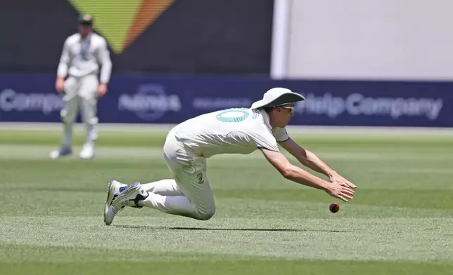 Australia's captain Pat Cummins dives to field the ball on the third day of the first cricket test between Australia and India in Perth, Australia, Sunday, Nov. 24, 2024. (AP Photo/Trevor Collens)