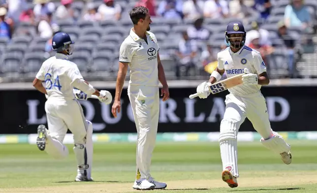 Australia's Mitchell Starc, center, watches as India's Devdutt Padikkal, right, and Yashasvi Jaiswal run between the wickets on the third day of the first cricket test between Australia and India in Perth, Australia, Sunday, Nov. 24, 2024. (AP Photo/Trevor Collens)