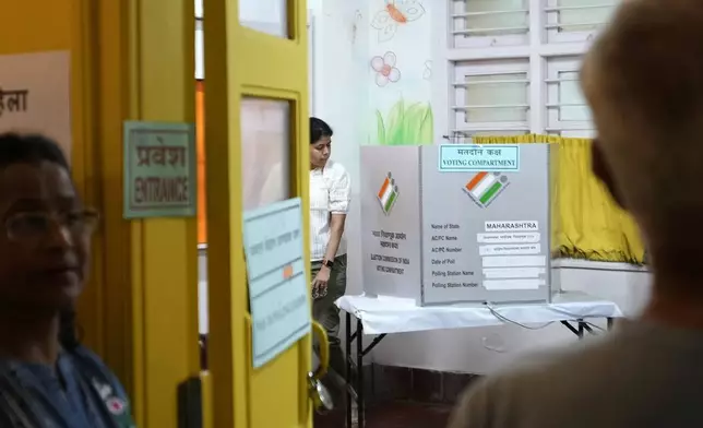 A woman walks out after casting her vote during Maharashtra state assembly elections in Mumbai, India, Wednesday, Nov 20, 2024. (AP Photo/Rajanish Kakade)