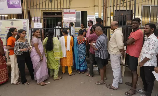 Indian people wait in a queue to cast their votes during Maharashtra state assembly elections in Mumbai, India, Wednesday, Nov. 20, 2024.(AP Photo/Rajanish Kakade)