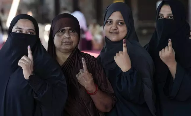Indian Muslim women show their ink marked fingers after casting their votes during Maharashtra state assembly elections in Mumbai, India, Wednesday, Nov. 20, 2024.(AP Photo/Rajanish Kakade)
