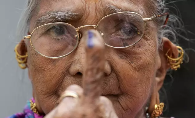 Elderly Indian woman Shantibai Chitroda shows her ink marked finger after casting her vote during Maharashtra state assembly elections in Mumbai, India, Wednesday, Nov. 20, 2024.(AP Photo/Rajanish Kakade)