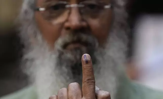 Senior citizen Amol Prabhu shows index finger after casting his votes during Maharashtra state assembly elections in Mumbai, India, Wednesday, Nov 20, 2024.(AP Photo/Rajanish Kakade)