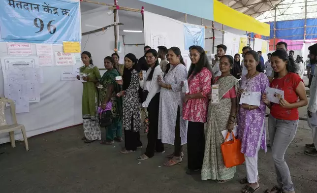 Indian women wait in a queue to cast their vote during Maharashtra state assembly elections in Mumbai, India, Wednesday, Nov. 20, 2024.(AP Photo/Rajanish Kakade)
