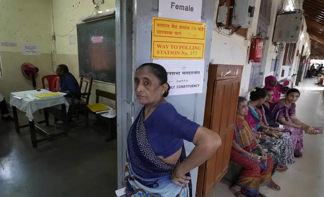 People wait in a queue to cast their votes during Maharashtra state assembly elections in Mumbai, India, Wednesday, Nov 20, 2024.(AP Photo/Rajanish Kakade)