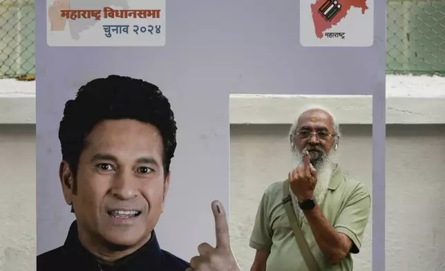 Senior citizen Amol Prabhu shows his index finger after casting his vote during Maharashtra state assembly elections in Mumbai, India, Wednesday, Nov 20, 2024. (AP Photo/Rajanish Kakade)