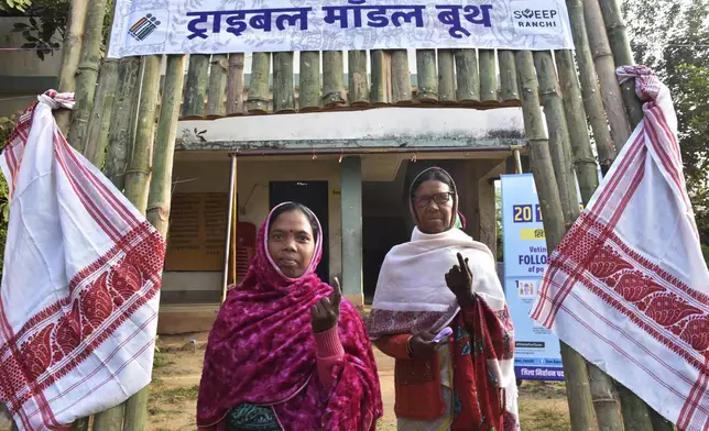 Tribal women show their indelible ink mark on their index fingers after casting their votes for state assembly elections on the outskirts of Ranchi in the Indian state of Jharkhand, Wednesday, Nov. 20, 2024. (AP Photo/Rajesh Kumar)