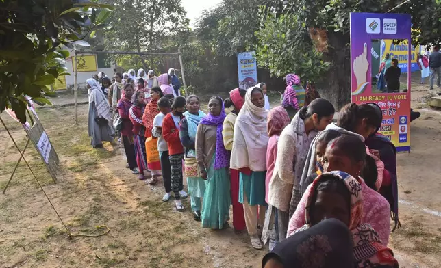 Tribal women stand in a queue to cast their votes for state assembly election on the outskirts of Ranchi in the Indian state of Jharkhand, Wednesday, Nov. 20, 2024. (AP Photo/Rajesh Kumar)