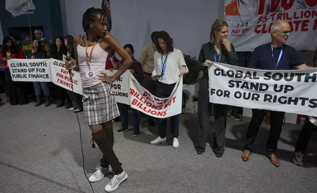 Activist Erica Njuguna leads a demonstration with signs reading "Global South: stand up for public finance" at the COP29 U.N. Climate Summit, Wednesday, Nov. 20, 2024, in Baku, Azerbaijan. (AP Photo/Peter Dejong)