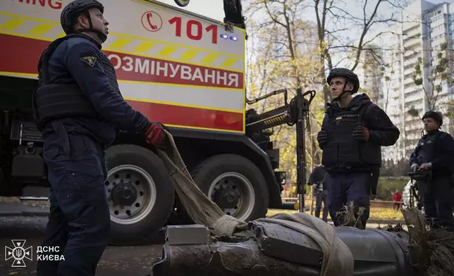 In this photo provided by the Ukrainian Emergency Service, emergency services personnel remove part of a Russian missile that hit an apartment house during massive missile attack in Kyiv, Ukraine, Sunday, Nov. 17, 2024. (Ukrainian Emergency Service via AP)