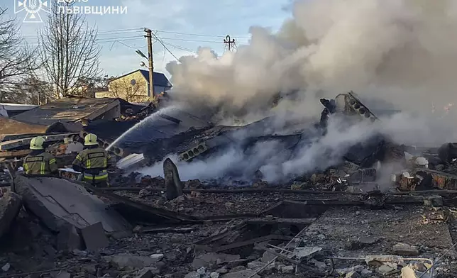 In this photo provided by the Ukrainian Emergency Service, emergency services personnel work to extinguish a fire following a Russian rocket attack in Lviv, Ukraine, Sunday, Nov. 17, 2024. (Ukrainian Emergency Service via AP)