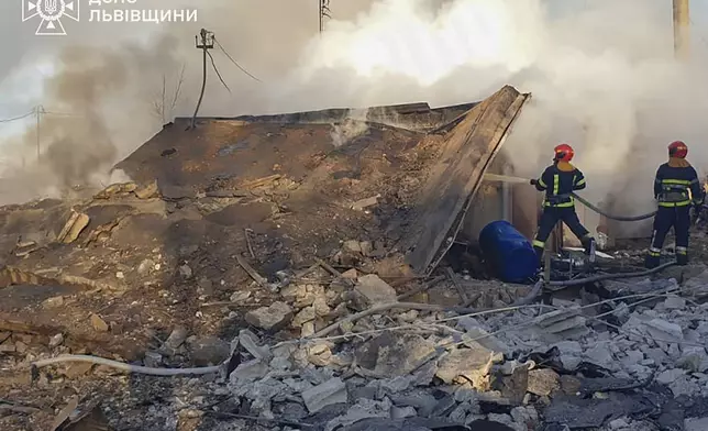 In this photo provided by the Ukrainian Emergency Service, emergency services personnel work to extinguish a fire following a Russian rocket attack in Lviv, Ukraine, Sunday, Nov. 17, 2024. (Ukrainian Emergency Service via AP)