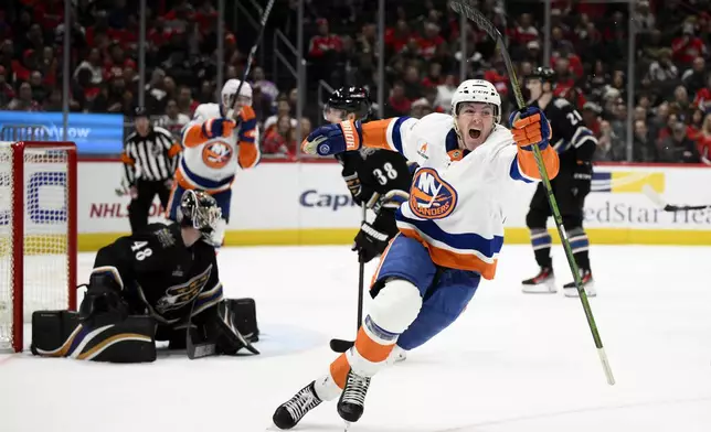 New York Islanders center Kyle MacLean, right, celebrates after his goal against Washington Capitals goaltender Logan Thompson (48) during the second period of an NHL hockey game, Friday, Nov. 29, 2024, in Washington. (AP Photo/Nick Wass)