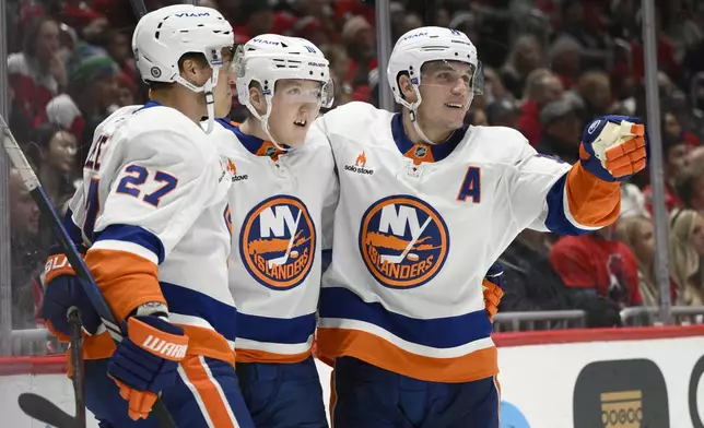 New York Islanders right wing Simon Holmstrom, center, celebrates after his goal with left wing Anders Lee (27) and center Bo Horvat, right, during the second period of an NHL hockey game against the Washington Capitals, Friday, Nov. 29, 2024, in Washington. (AP Photo/Nick Wass)