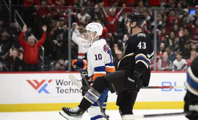 Washington Capitals right wing Tom Wilson (43) celebrates his goal next to New York Islanders right wing Simon Holmstrom (10) during the first period of an NHL hockey game, Friday, Nov. 29, 2024, in Washington. (AP Photo/Nick Wass)