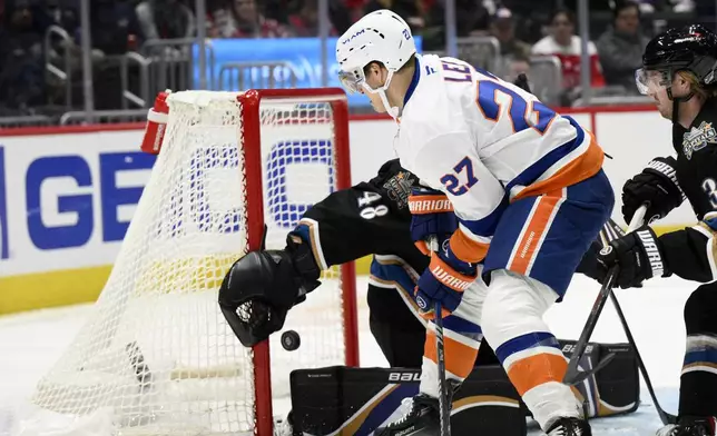 New York Islanders left wing Anders Lee (27) scores past Washington Capitals goaltender Logan Thompson (48) during the second period of an NHL hockey game, Friday, Nov. 29, 2024, in Washington. (AP Photo/Nick Wass)