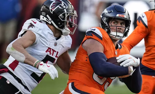 Denver Broncos linebacker Cody Barton (55) is tackled after his interception by Atlanta Falcons wide receiver Drake London (5) during the second half of an NFL football game, Sunday, Nov. 17, 2024, in Denver. (AP Photo/Jack Dempsey)