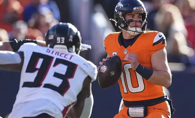 Denver Broncos quarterback Bo Nix (10) works in the pocket as Atlanta Falcons defensive tackle Kentavius Street (93) pressures during the first half of an NFL football game, Sunday, Nov. 17, 2024, in Denver. (AP Photo/David Zalubowski)