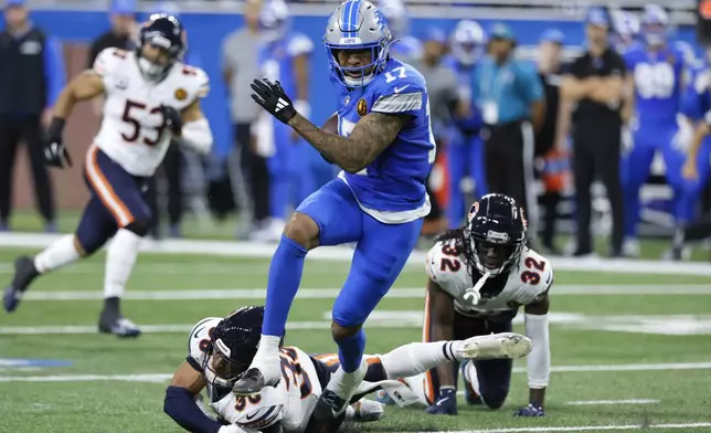 Detroit Lions wide receiver Tim Patrick (17) escapes the tackle of Chicago Bears safety Jonathan Owens (36) during the first half of an NFL football game, Sunday, Nov. 17, 2024, in Detroit. (AP Photo/Duane Burleson)