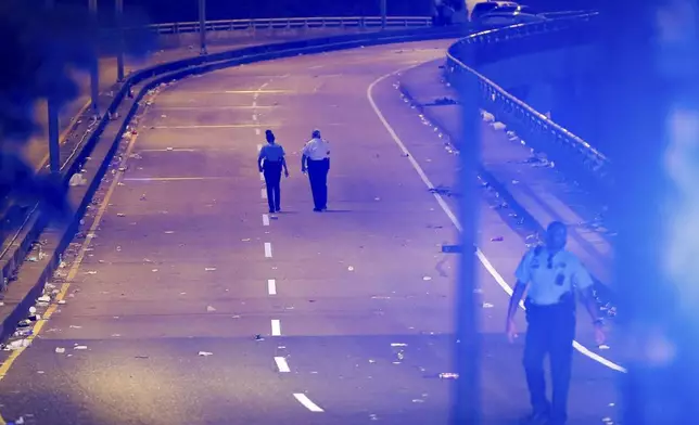 New Orleans police walk up the Almonaster Avenue bridge after a deadly shooting in New Orleans, Sunday, Nov. 17, 2024. (David Grunfeld/The Times-Picayune/The New Orleans Advocate via AP)